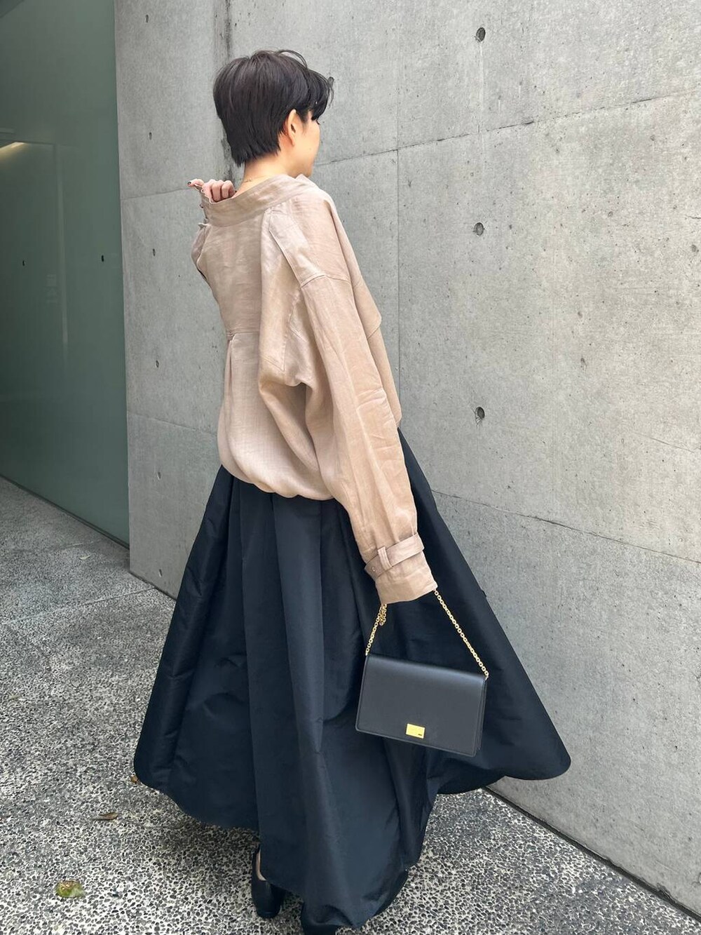 グレー系のブルゾン、ブラック系のスカート、ブラウン系のニット/セーターを着用したレディースの春コーディネートの5枚目の写真