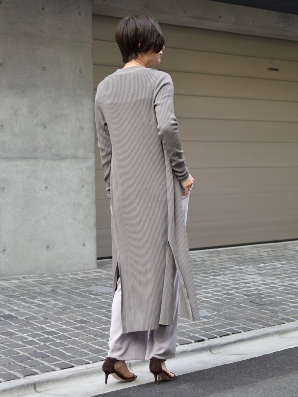 グレー系のタンクトップ、ピンク系のスラックス、グレー系のカーディガン/ボレロを着用したレディースの冬コーディネートの3枚目の写真