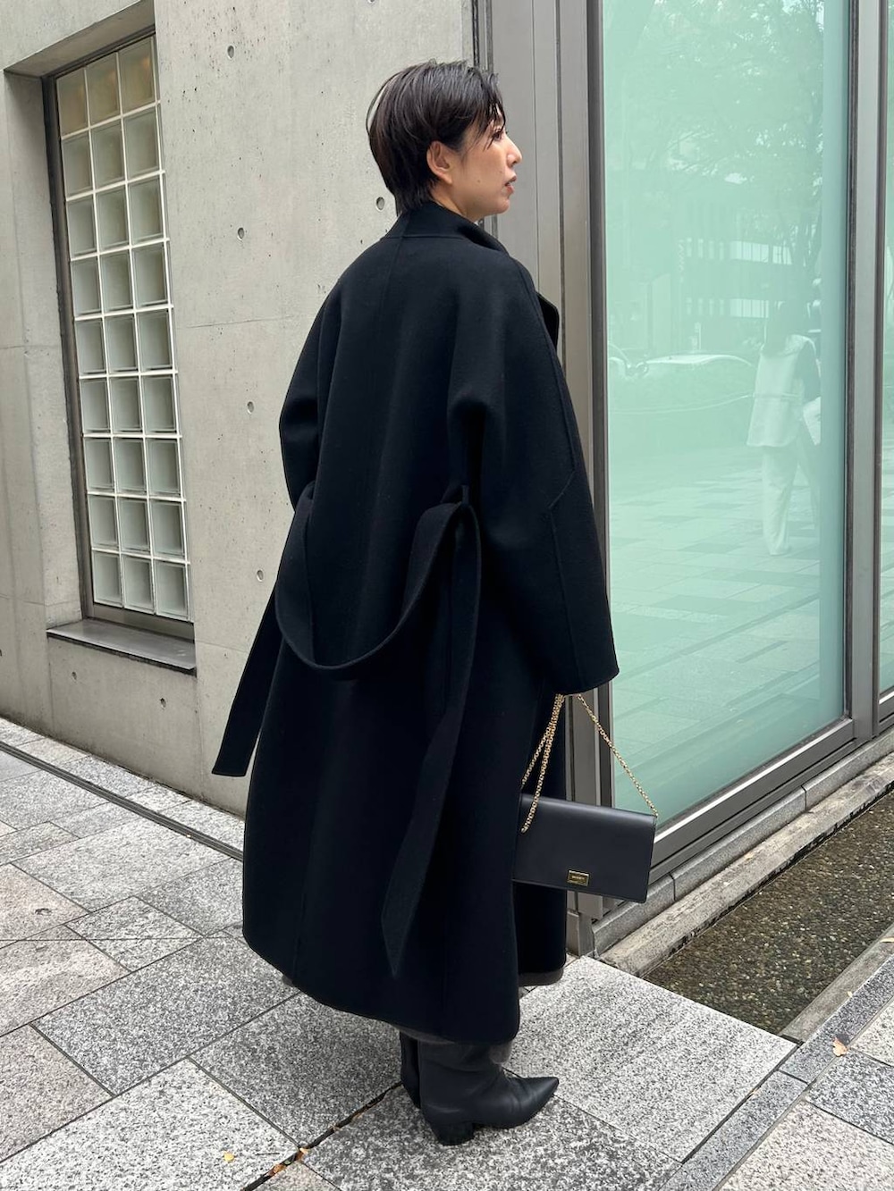 ブラック系のその他トップス、ブラック系のノーカラーコート、グレー系のスカートを着用したレディースの秋コーディネートの8枚目の写真