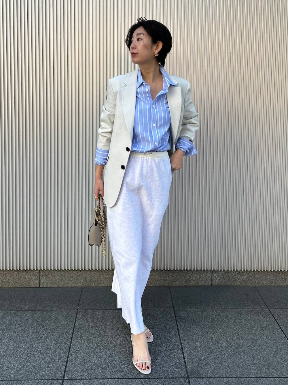 その他のシャツ/ブラウス、グレー系のスカート、ホワイト系のテーラードジャケットを着用したレディースの冬コーディネートの2枚目の写真