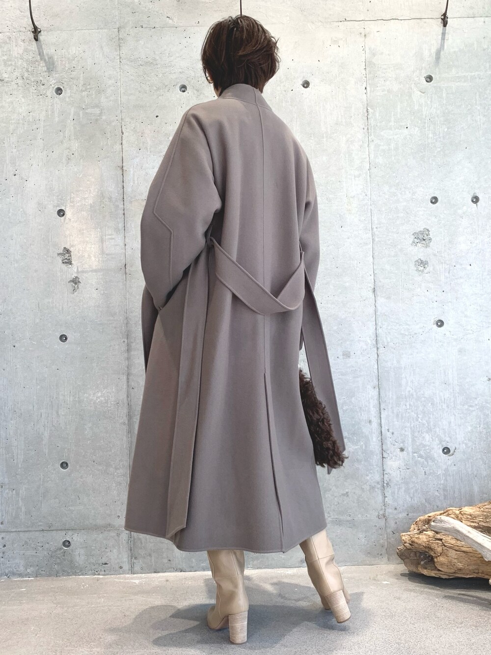 グレー系のニット/セーター、ベージュ系のトップス、ベージュ系のスカートを着用したレディースの秋コーディネートの3枚目の写真