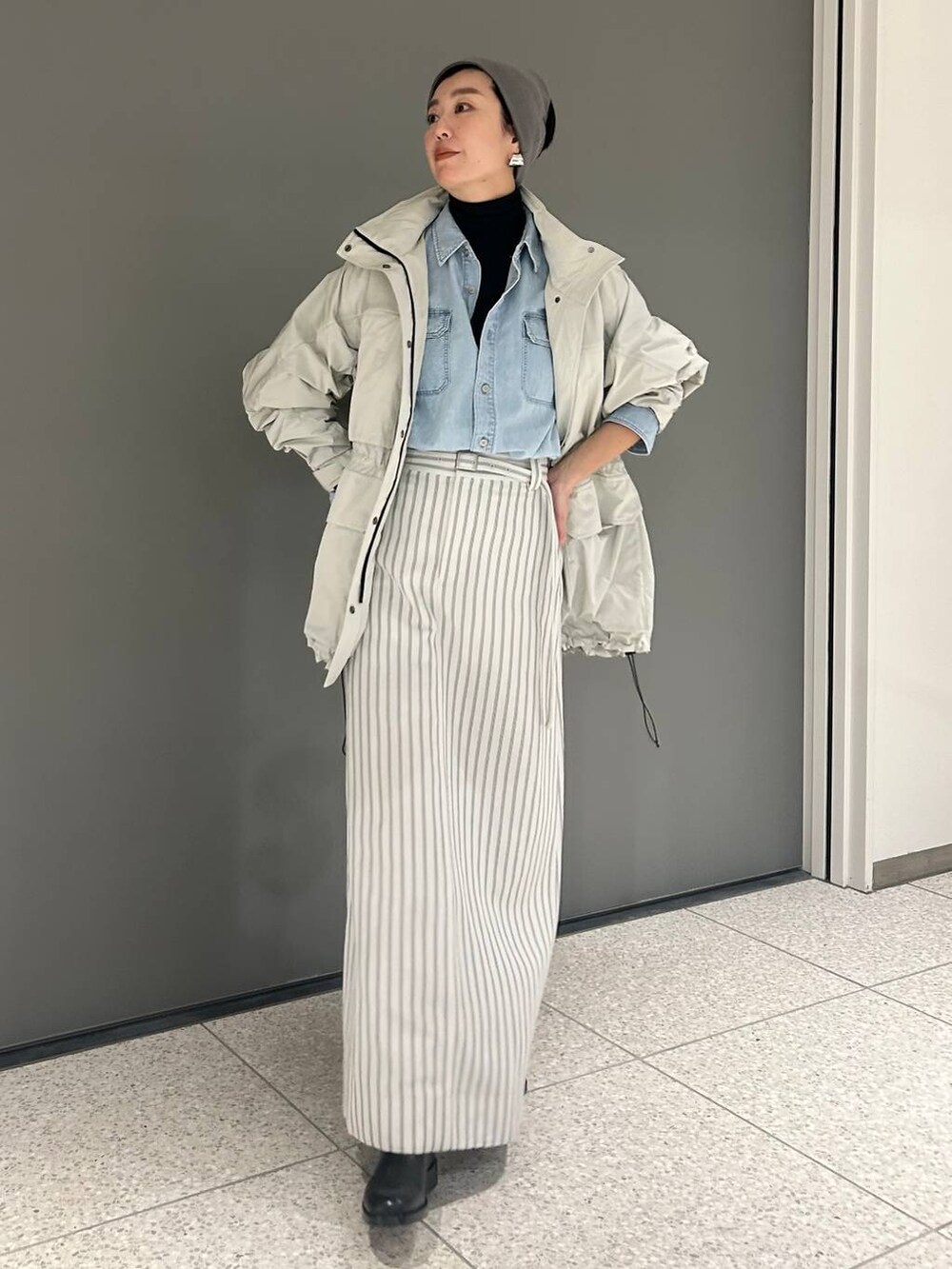 ブルー系のシャツ/ブラウス、ブルー系のニット/セーター、グレー系のブルゾンを着用したレディースの冬コーディネートの2枚目の写真