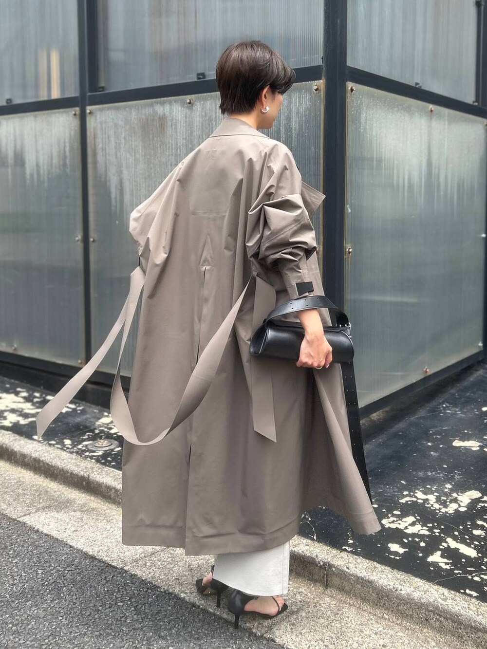 ベージュ系のシャツ/ブラウス、ブラウン系のトレンチコート、ブラック系のサンダルを着用したレディースの夏コーディネートの5枚目の写真