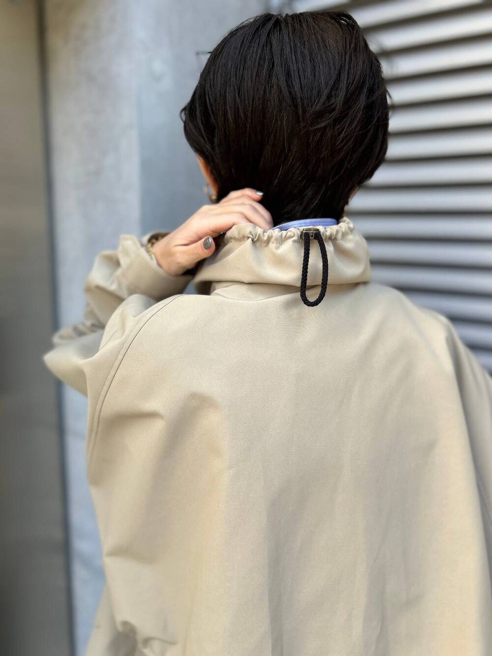 グレー系のニット/セーター、ブルー系のシャツ/ブラウス、グレー系のスラックスを着用したレディースの冬コーディネートの9枚目の写真