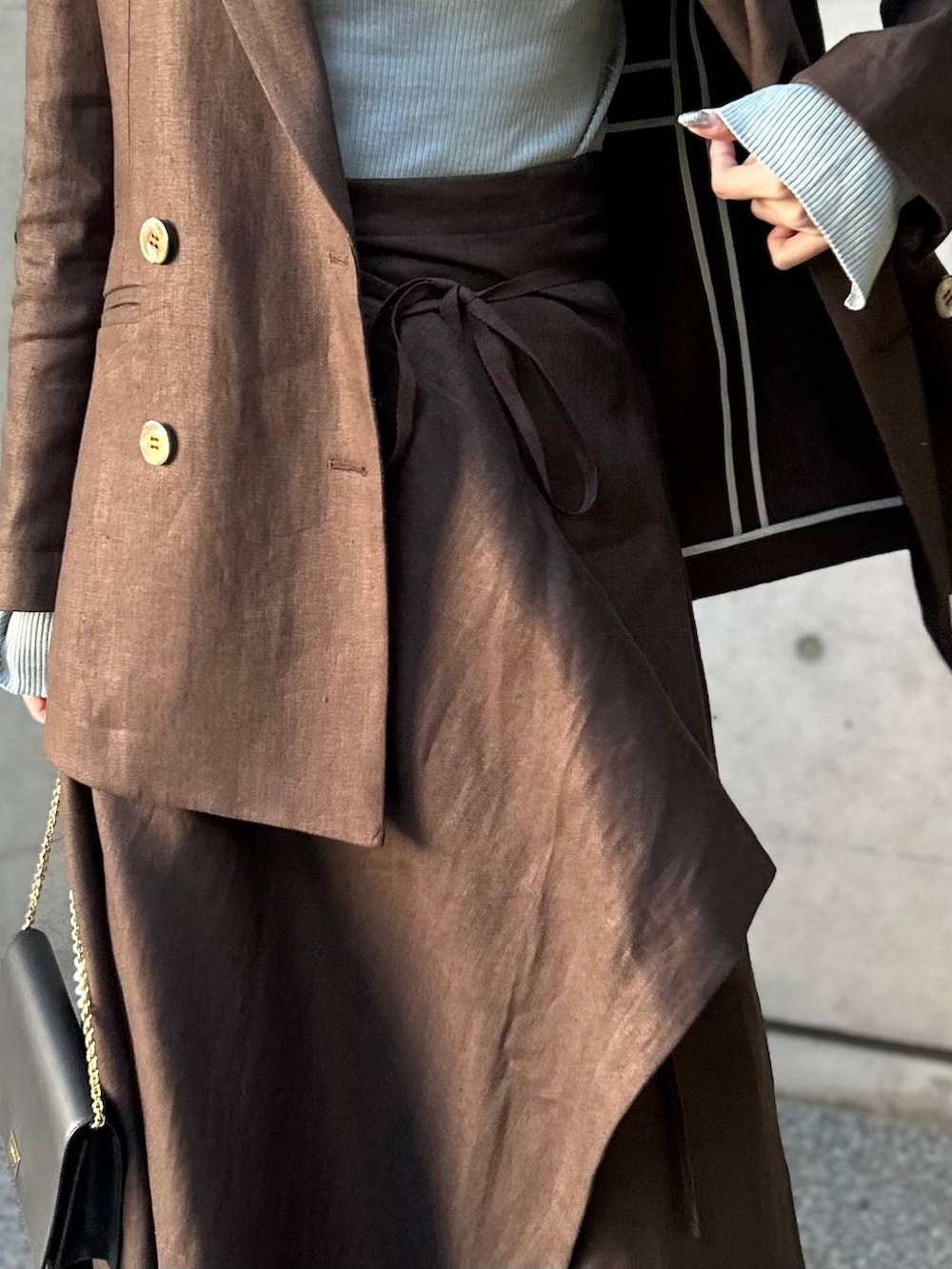 ブルー系のニット/セーター、ブラウン系のテーラードジャケット、ブラウン系のスカートを着用したレディースの冬コーディネートの9枚目の写真