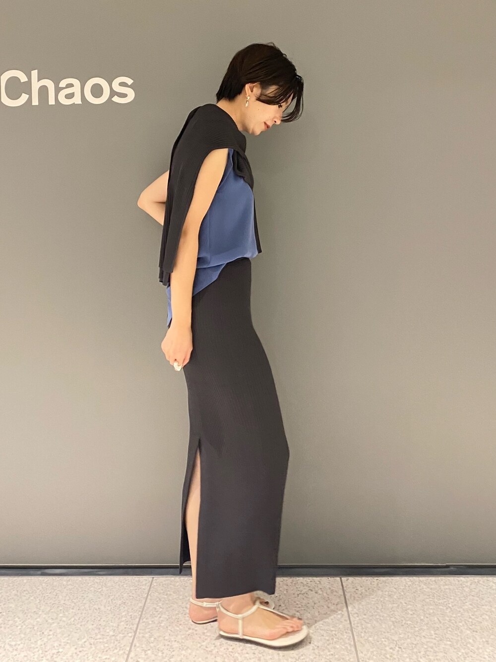 ブルー系のTシャツ/カットソー、ホワイト系のサンダル、グレー系のスカートを着用したレディースの夏コーディネートの2枚目の写真