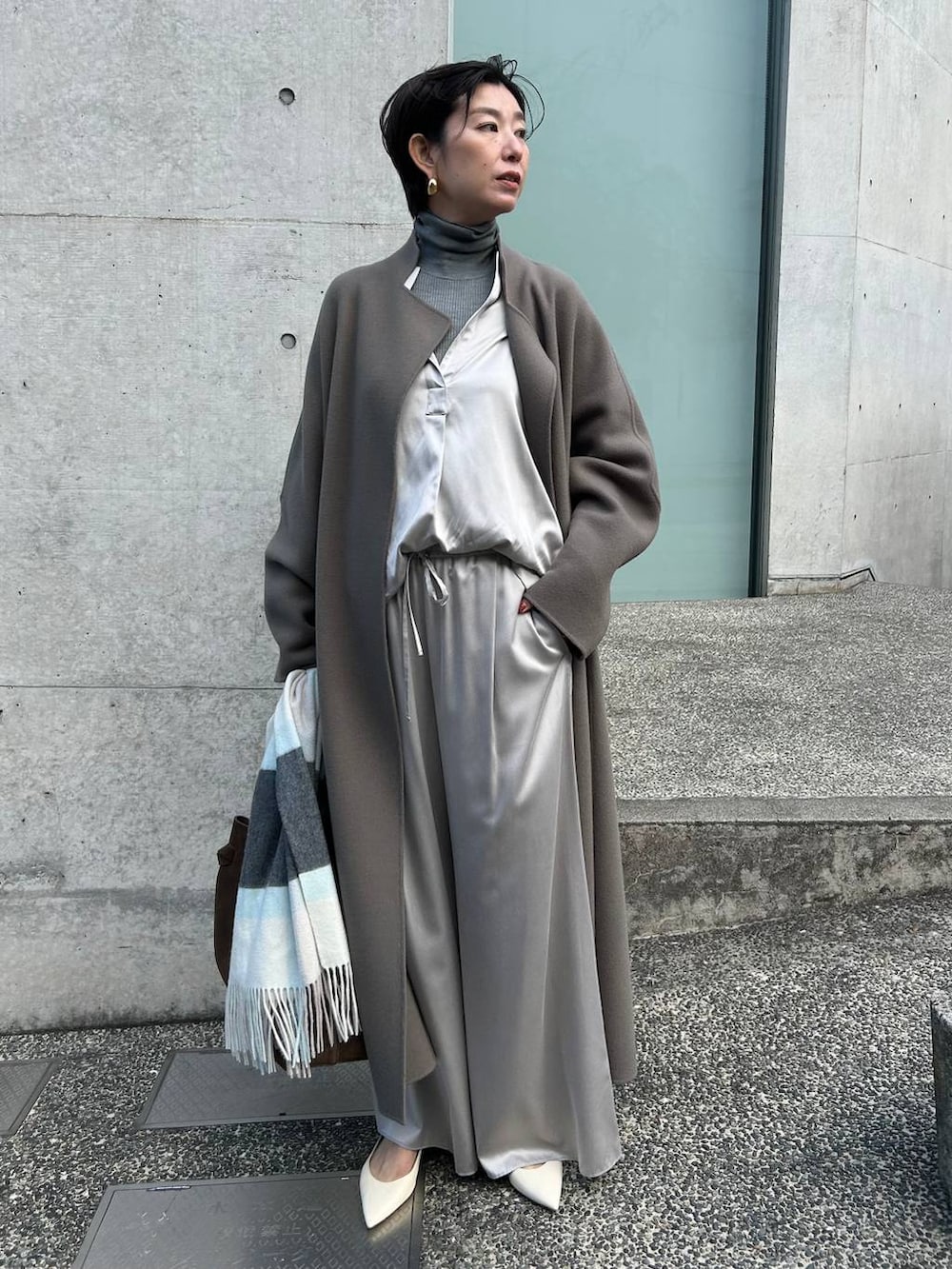 グレー系のその他パンツ、グレー系のニット/セーター、ブラウン系のノーカラーコートを着用したレディースの秋コーディネートの2枚目の写真