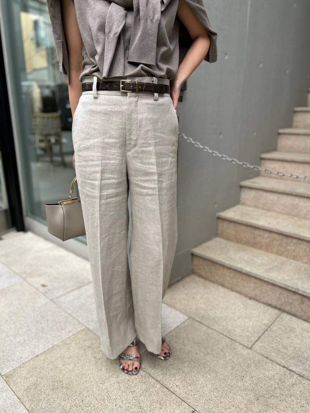 ホワイト系のスラックス、ブラウン系のニット/セーター、ブラウン系のカーディガン/ボレロを着用したレディースの春コーディネートの7枚目の写真