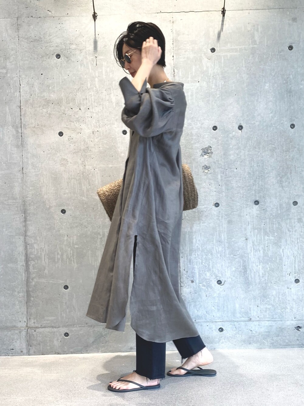 グリーン系のワンピース、ブラック系のデニムパンツ、ブラック系のサンダルを着用したレディースの夏コーディネートの2枚目の写真