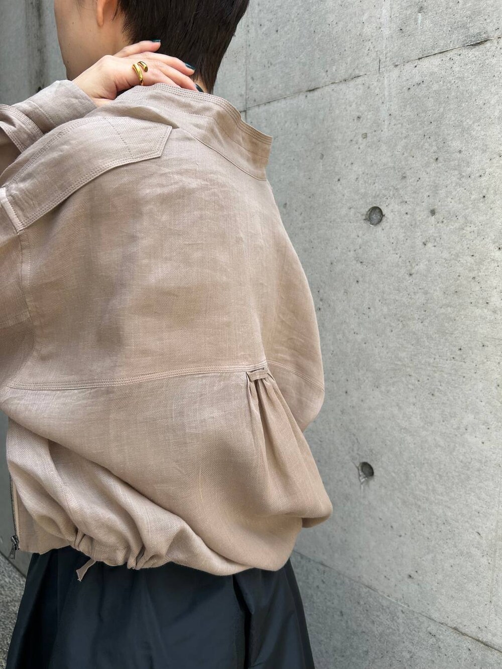 グレー系のブルゾン、ブラック系のスカート、ブラウン系のニット/セーターを着用したレディースの春コーディネートの8枚目の写真