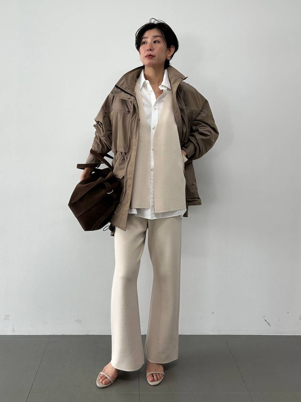 ホワイト系のシャツ/ブラウス、ベージュ系のベスト、ベージュ系のブルゾンを着用したレディースの冬コーディネートの2枚目の写真