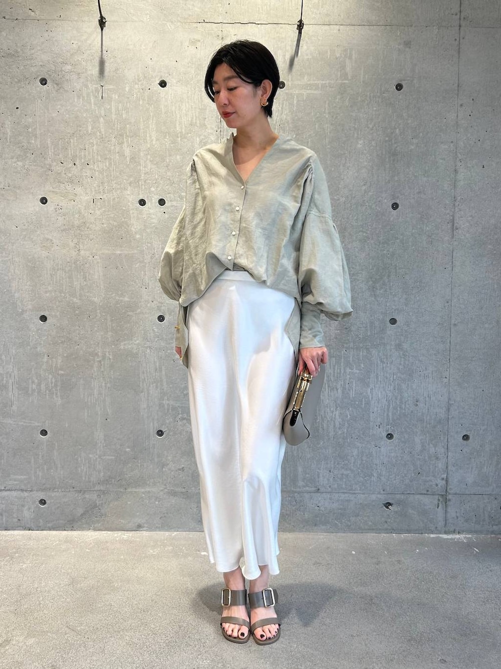 グリーン系のシャツ/ブラウス、ホワイト系のスカートを着用したレディースの春コーディネートの2枚目の写真