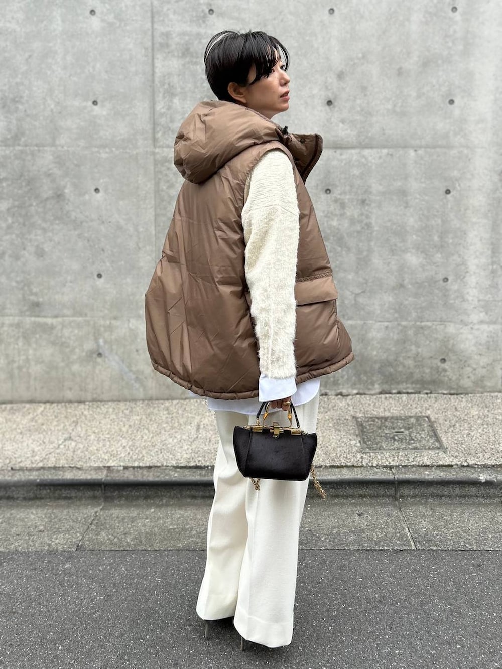 ホワイト系のシャツ/ブラウス、ホワイト系のニット/セーター、ホワイト系のスラックスを着用したレディースの秋コーディネートの2枚目の写真