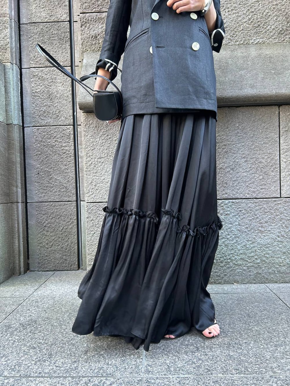 ベージュ系のタンクトップ、ブラック系のサンダル、ブラック系のテーラードジャケットを着用したレディースの冬コーディネートの8枚目の写真