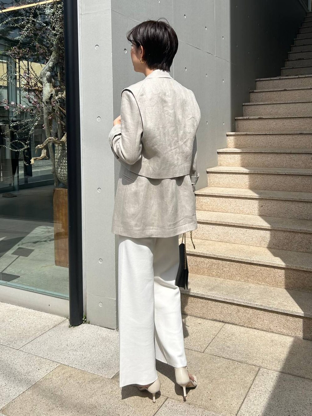 ホワイト系のその他パンツ、ホワイト系のタンクトップ、ベージュ系のナイロンジャケットを着用したレディースの春コーディネートの6枚目の写真