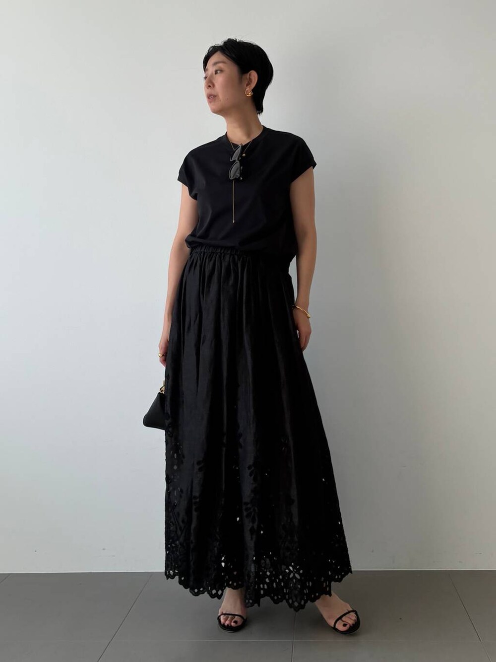 ブラック系のTシャツ/カットソー、ブラック系のスカートを着用したレディースの春コーディネートの2枚目の写真