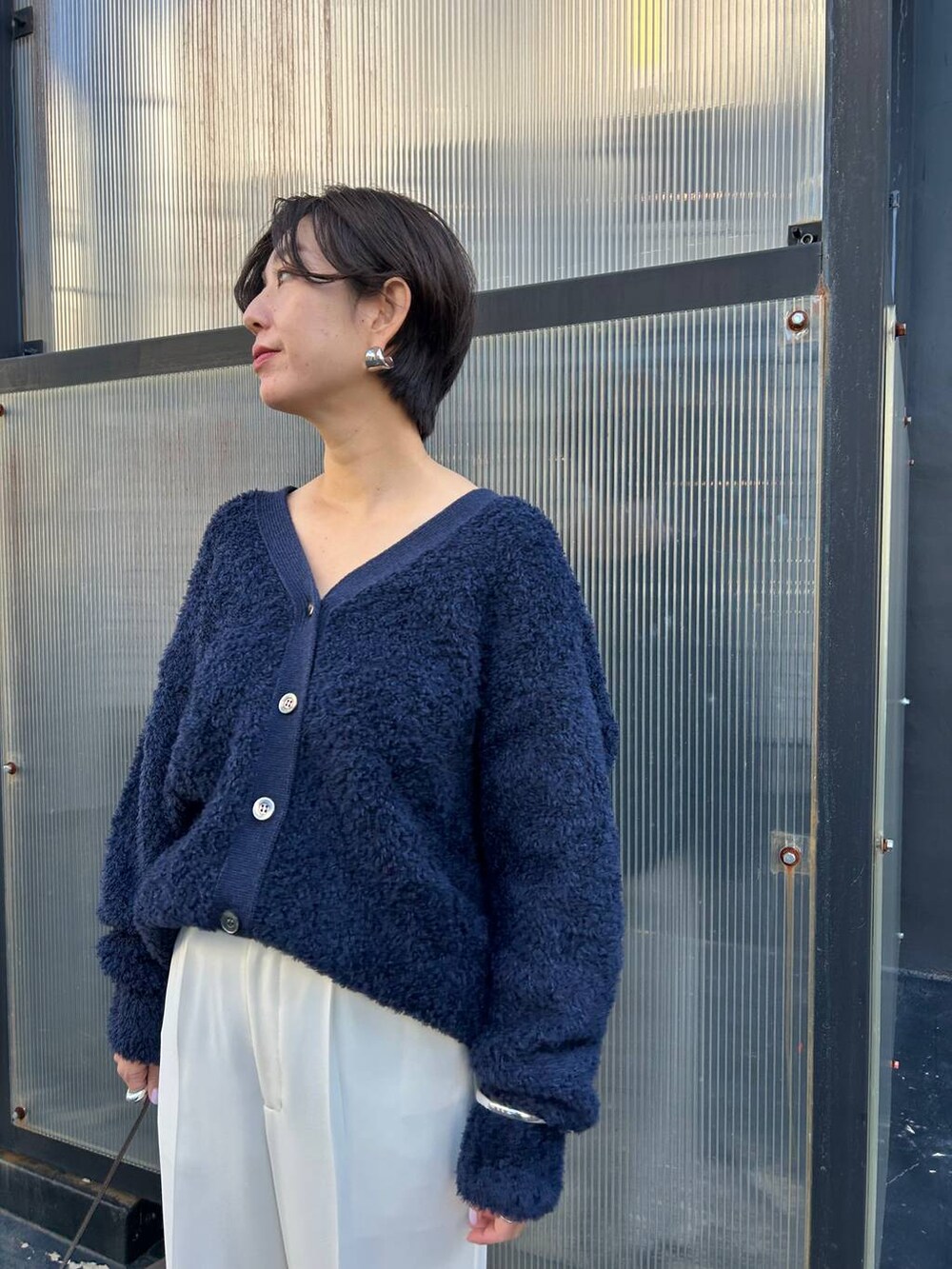 ブルー系のカーディガン/ボレロ、グレー系のノーカラーコート、ホワイト系のスラックスを着用したレディースの冬コーディネートの8枚目の写真