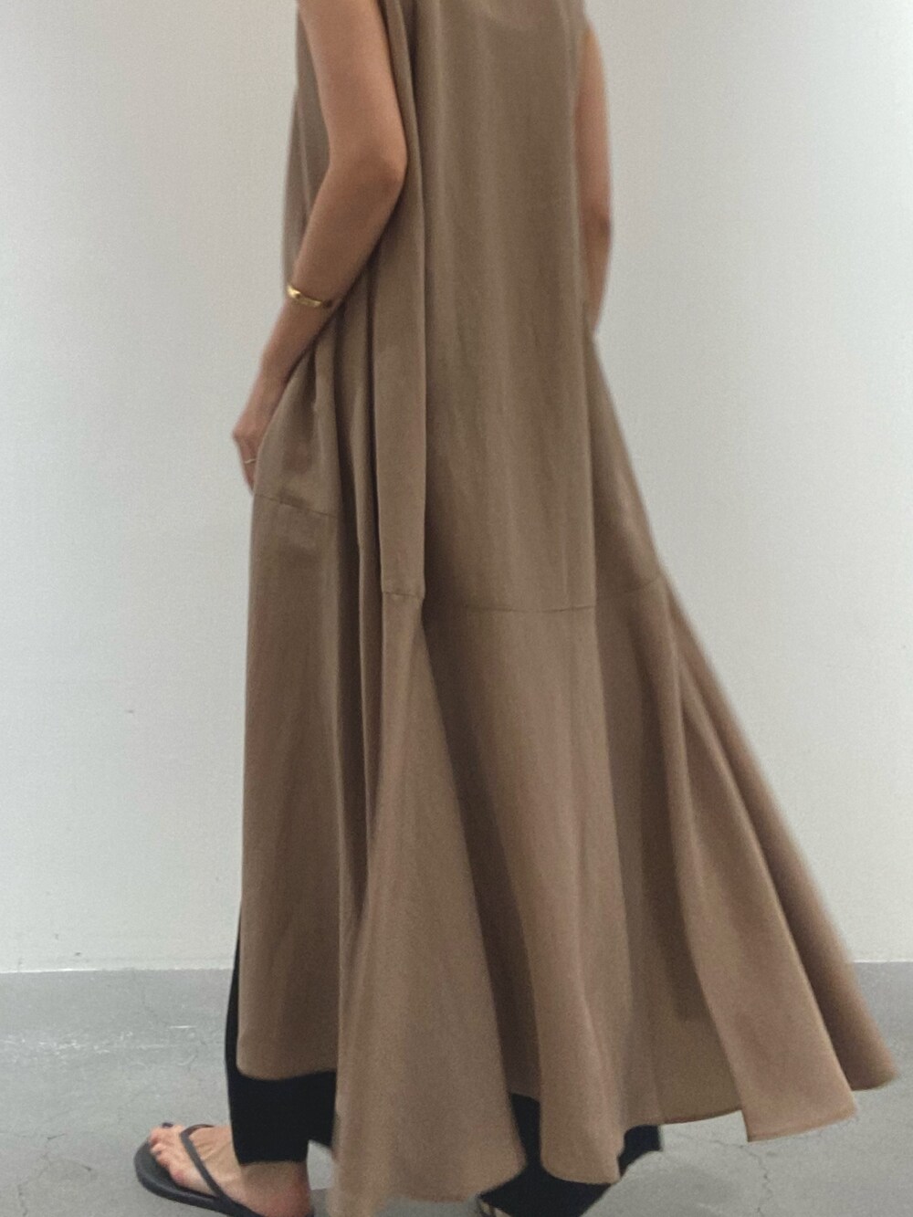 イエロー系のワンピース、ブラック系のタンクトップ、ブラック系のその他パンツを着用したレディースの夏コーディネートの3枚目の写真