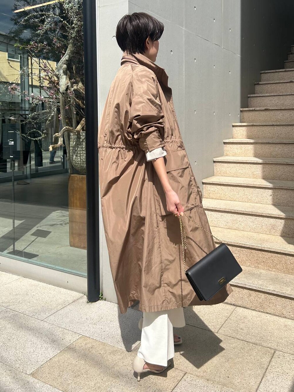 ホワイト系のその他パンツ、ホワイト系のタンクトップ、ベージュ系のナイロンジャケットを着用したレディースの春コーディネートの3枚目の写真