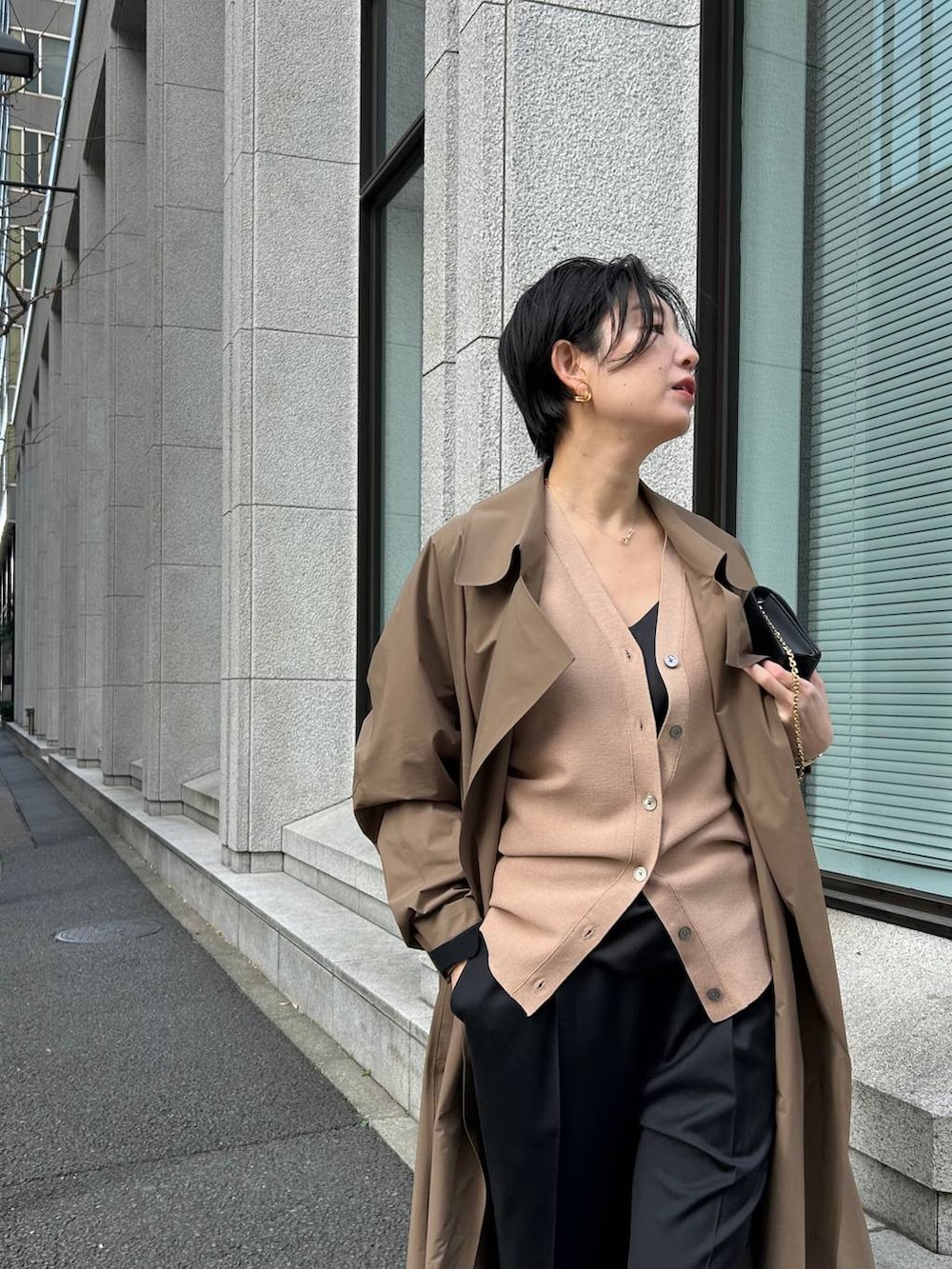 ブラック系のキャミソール、ブラック系のスラックス、ブラウン系のカーディガン/ボレロを着用したレディースの冬コーディネートの4枚目の写真