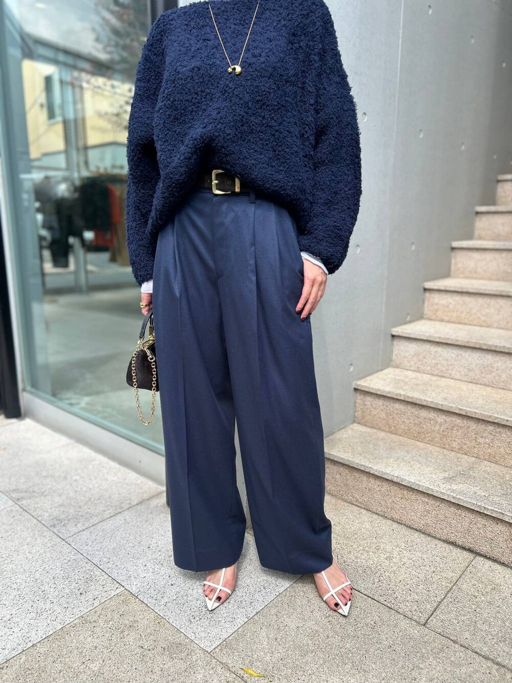 ブルー系のニット/セーター、ホワイト系のその他トップス、ブルー系のスラックスを着用したレディースの秋コーディネートの8枚目の写真