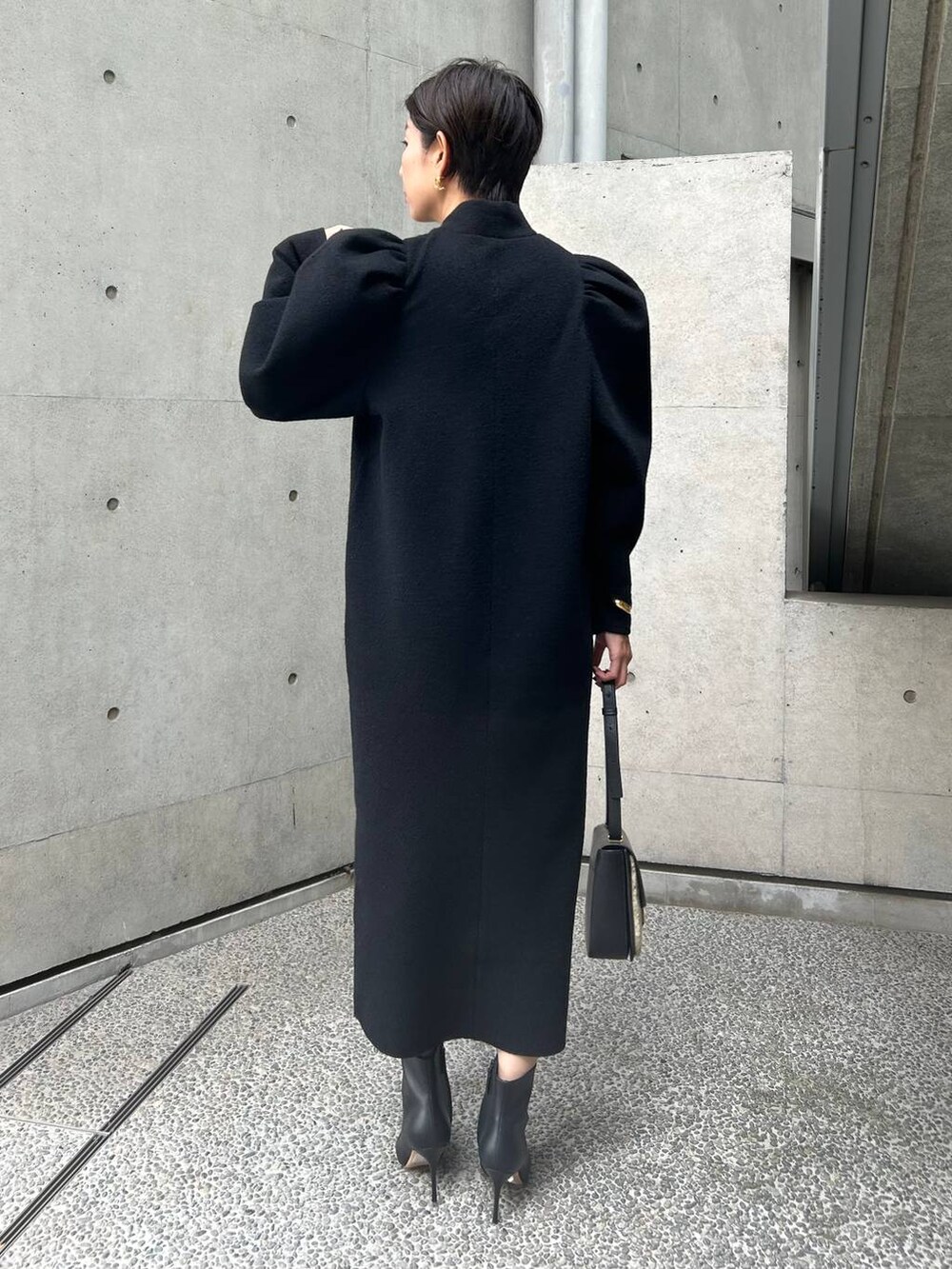 ブラック系のワンピースを着用したレディースの秋コーディネートの5枚目の写真