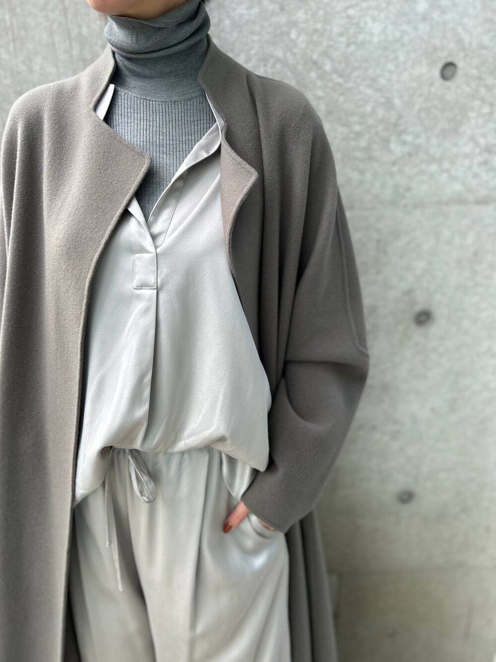 グレー系のその他パンツ、グレー系のニット/セーター、ブラウン系のノーカラーコートを着用したレディースの秋コーディネートの6枚目の写真