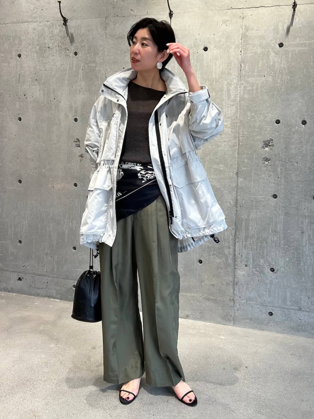 ブラック系のチューブトップ、グリーン系のニット/セーター、グリーン系のスラックスを着用したレディースの春コーディネートの8枚目の写真