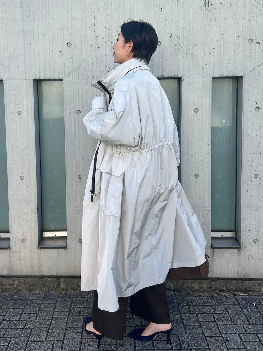 ブルー系のニット/セーター、ホワイト系のその他トップス、グレー系のナイロンジャケットを着用したレディースの冬コーディネートの3枚目の写真