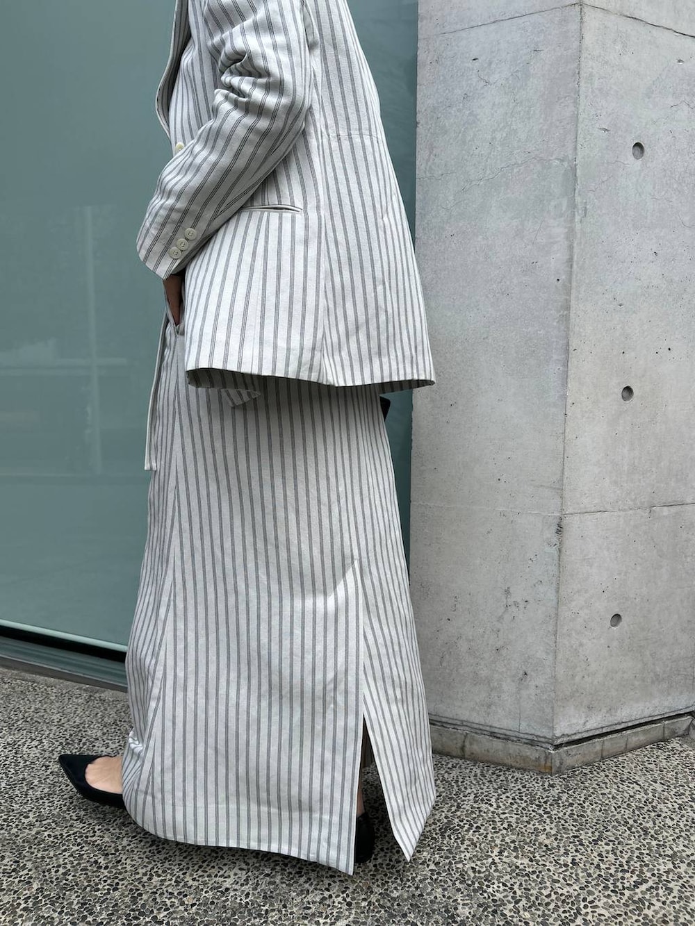 ブルー系のニット/セーター、ホワイト系のテーラードジャケット、ホワイト系のスカートを着用したレディースの冬コーディネートの9枚目の写真