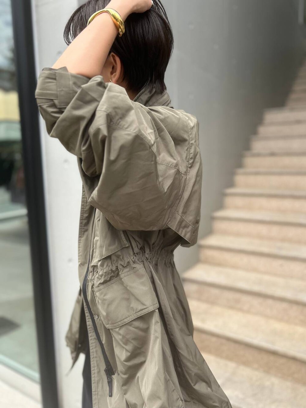 グレー系のTシャツ/カットソー、グリーン系のブルゾン、ブルー系のスラックスを着用したレディースの夏コーディネートの7枚目の写真