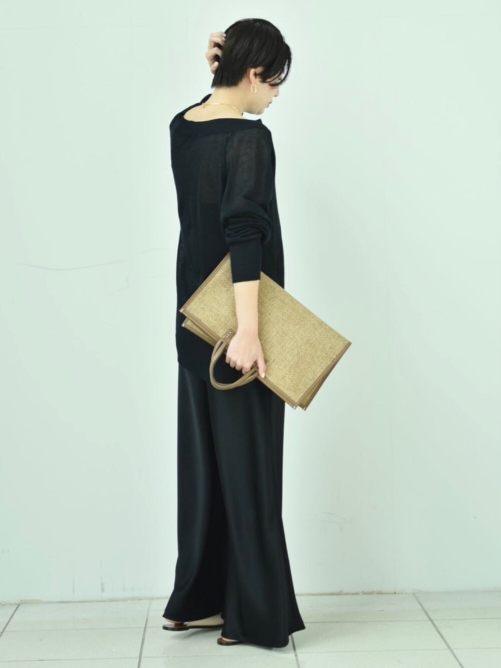 ブラック系のニット/セーター、ブラック系のその他パンツ、ブラウン系のバッグを着用したレディースの春コーディネートの2枚目の写真