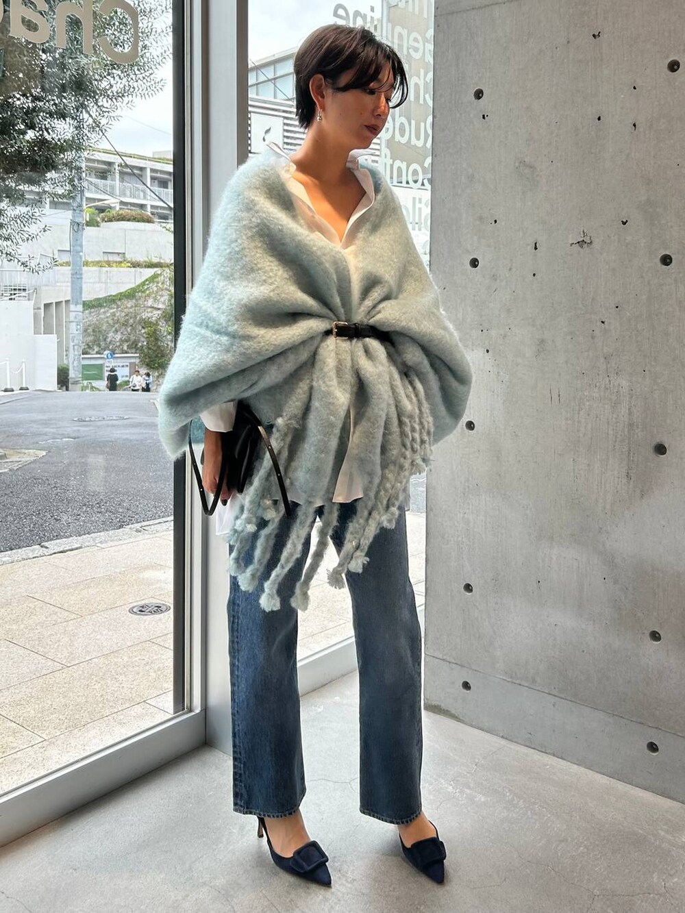 ブルー系のデニムパンツ、ホワイト系のシャツ/ブラウス、ブルー系のマフラーを着用したレディースの秋コーディネートの3枚目の写真