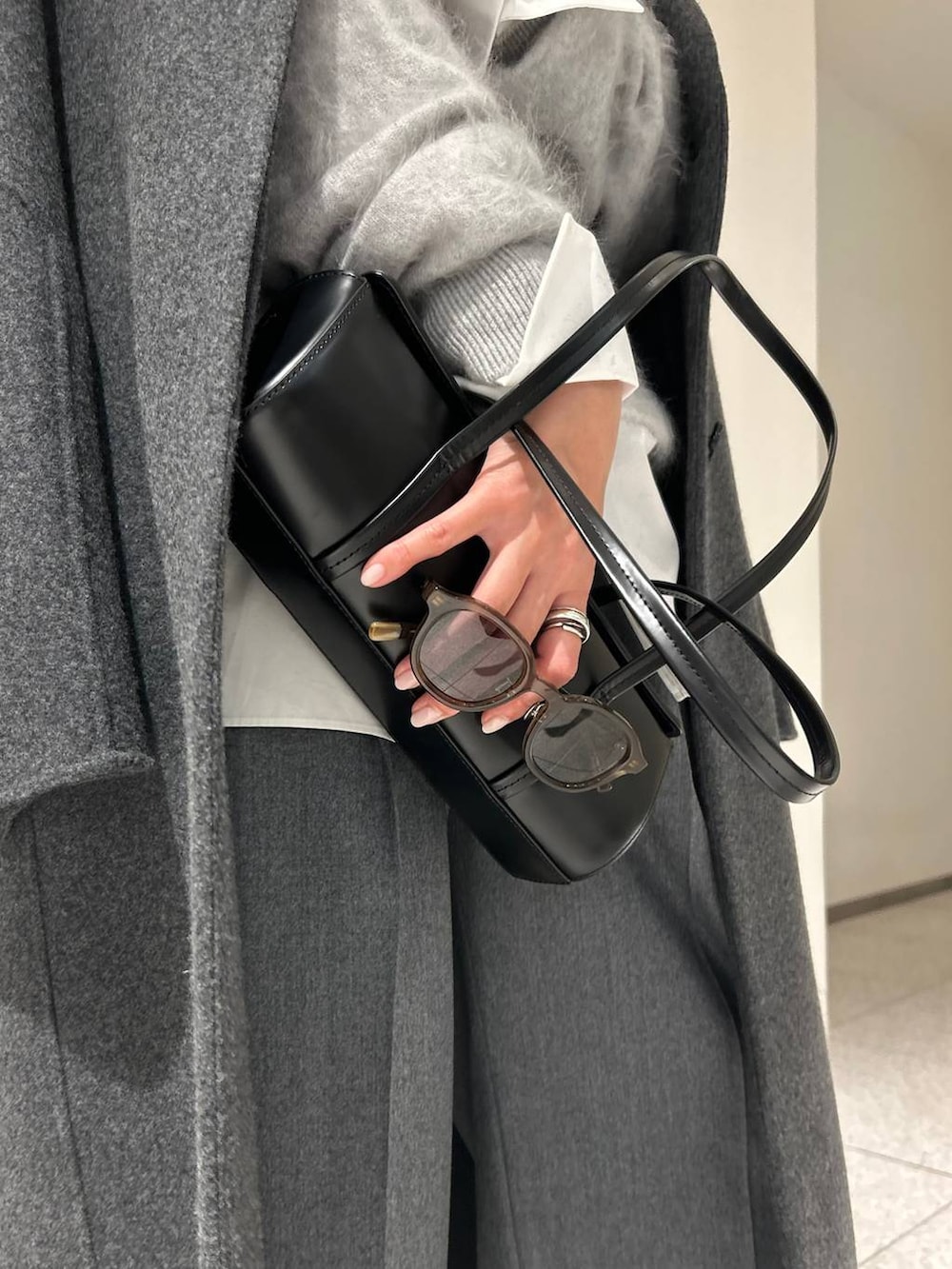 グレー系のニット/セーター、ホワイト系のシャツ/ブラウス、グレー系のスラックスを着用したレディースの秋コーディネートの8枚目の写真