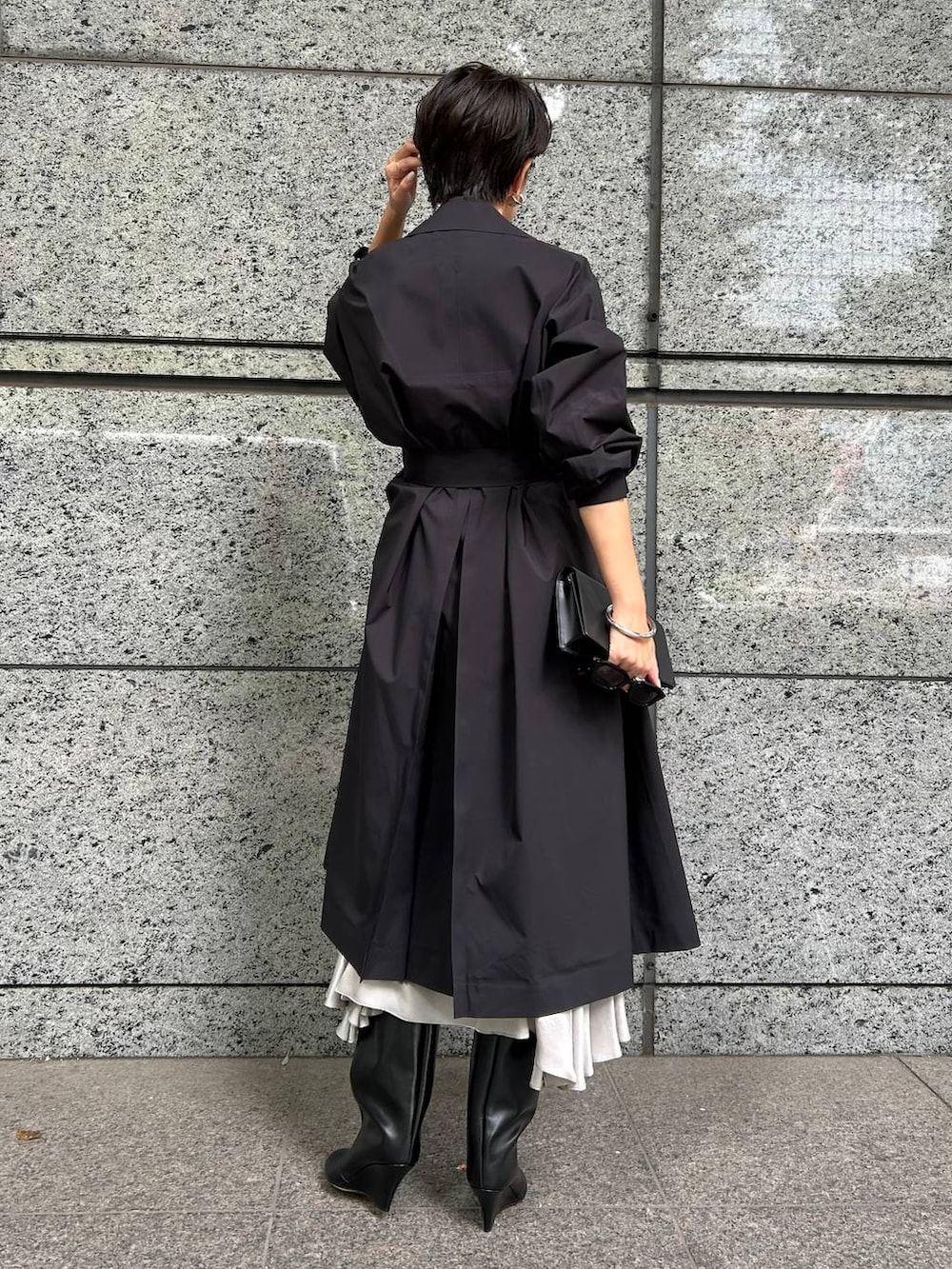 ブラック系のトレンチコート、グレー系のワンピースを着用したレディースの秋コーディネートの4枚目の写真
