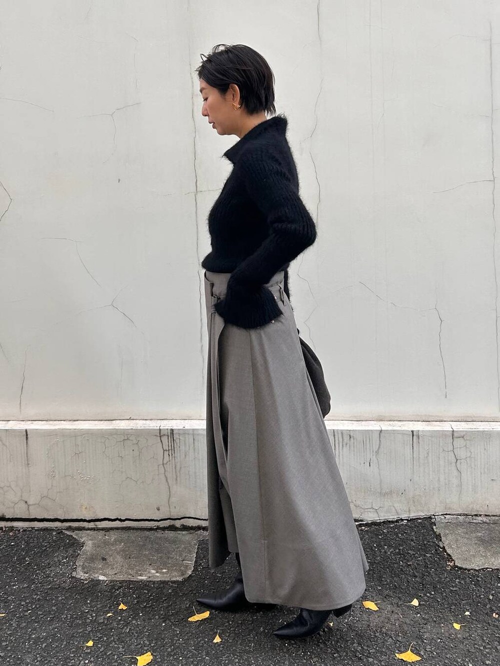 ブラック系のニット/セーター、ベージュ系のスカート、ブラウン系のストール/ショールを着用したレディースの冬コーディネートの2枚目の写真