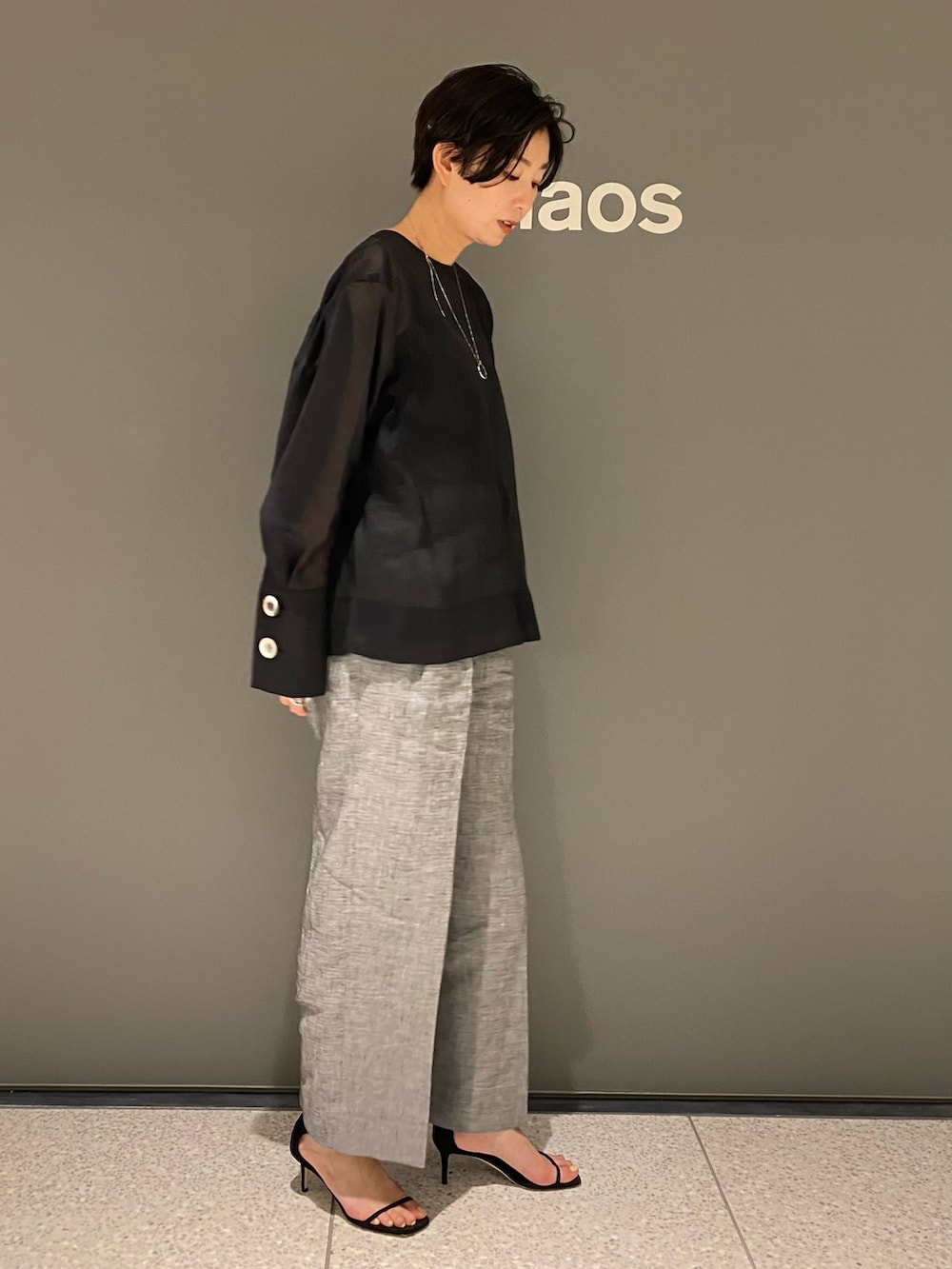 ブラック系のシャツ/ブラウス、ブラック系のタンクトップ、グレー系のパンツを着用したレディースの春コーディネートの2枚目の写真