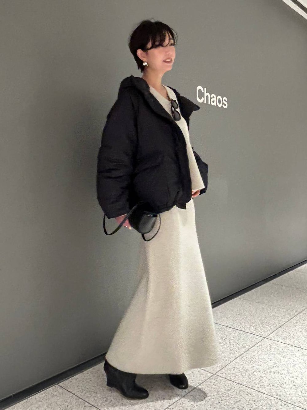 ベージュ系のニット/セーター、ベージュ系のスカート、グレー系のダウンジャケット/コートを着用したレディースの秋コーディネートの3枚目の写真