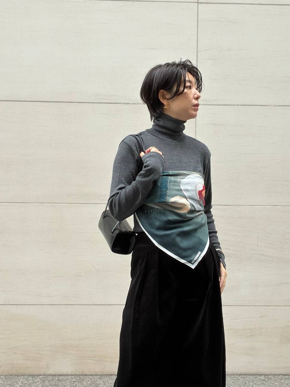 グレー系のニット/セーター、ホワイト系のその他アウター、グレー系のストール/ショールを着用したレディースの秋コーディネートの6枚目の写真