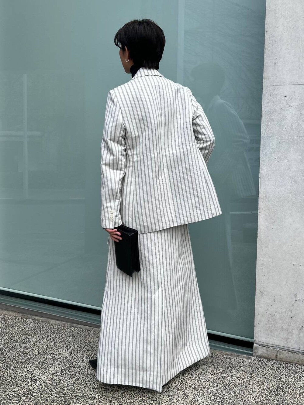 ブルー系のニット/セーター、ホワイト系のテーラードジャケット、ホワイト系のスカートを着用したレディースの冬コーディネートの5枚目の写真