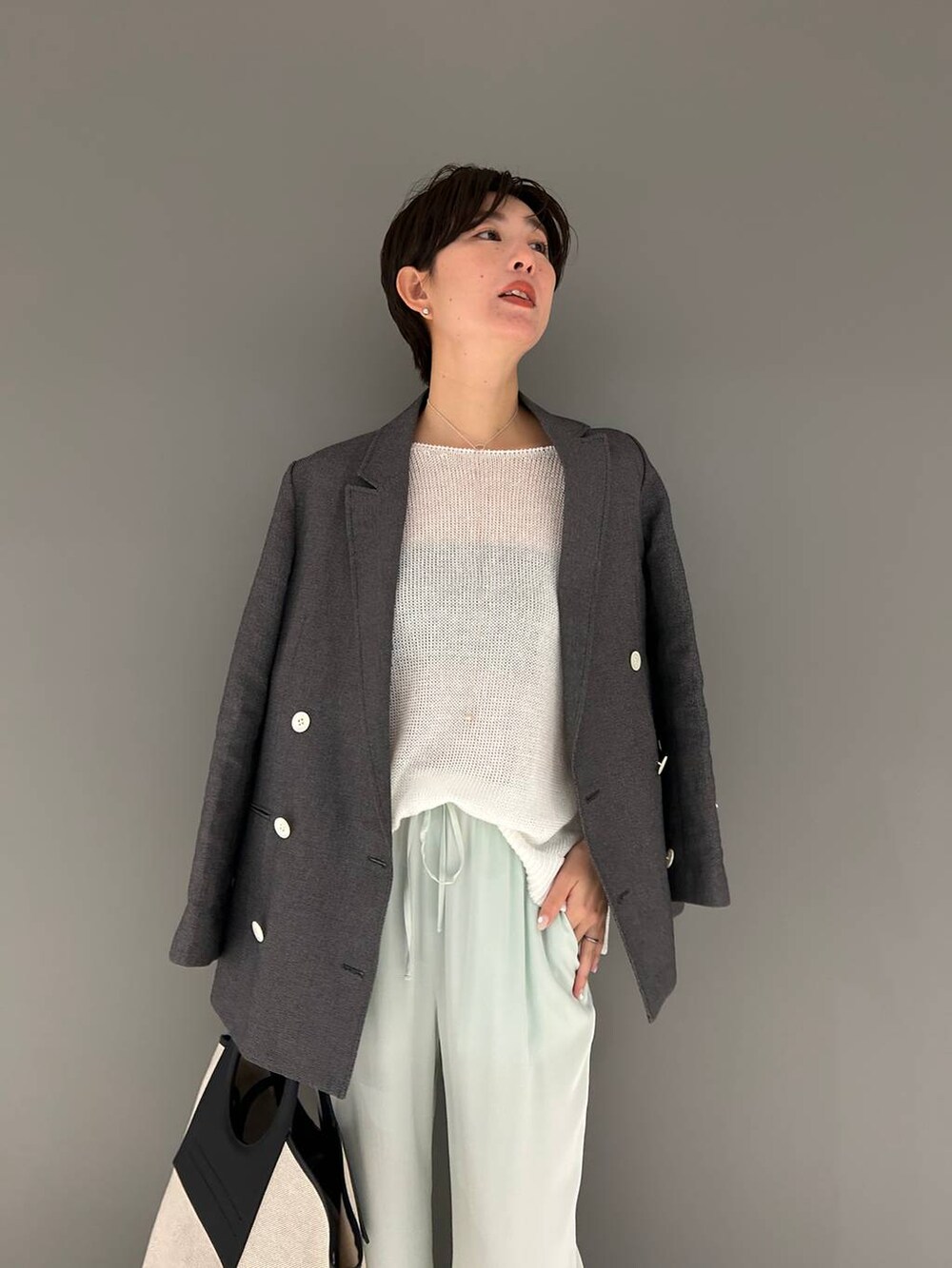 グリーン系のその他パンツ、ホワイト系のニット/セーター、ブラック系のテーラードジャケットを着用したレディースの春コーディネートの7枚目の写真