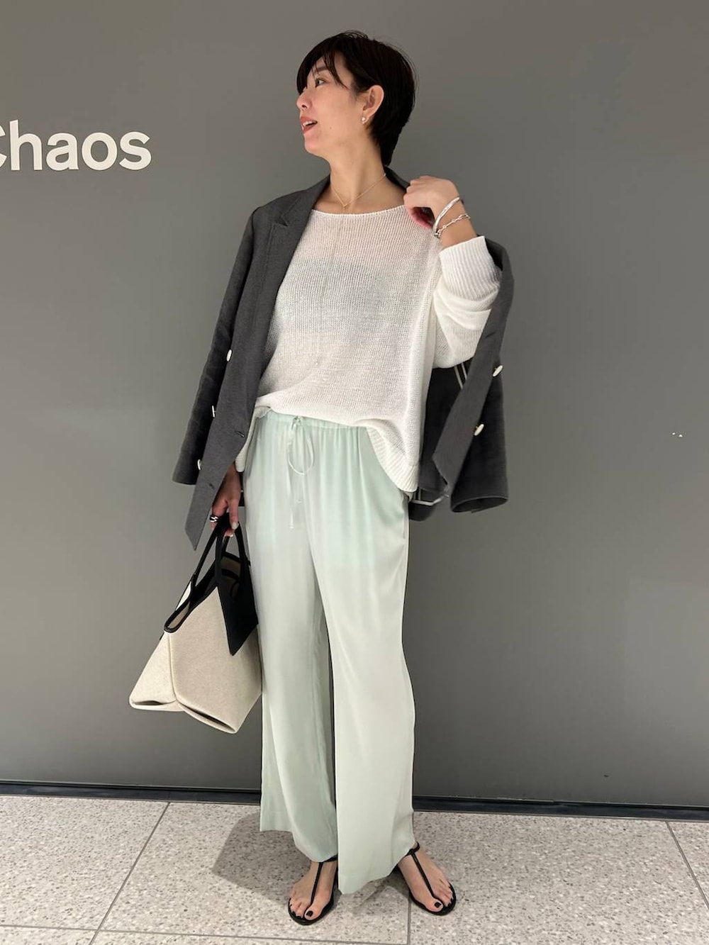 グリーン系のその他パンツ、ホワイト系のニット/セーター、ブラック系のテーラードジャケットを着用したレディースの春コーディネートの3枚目の写真