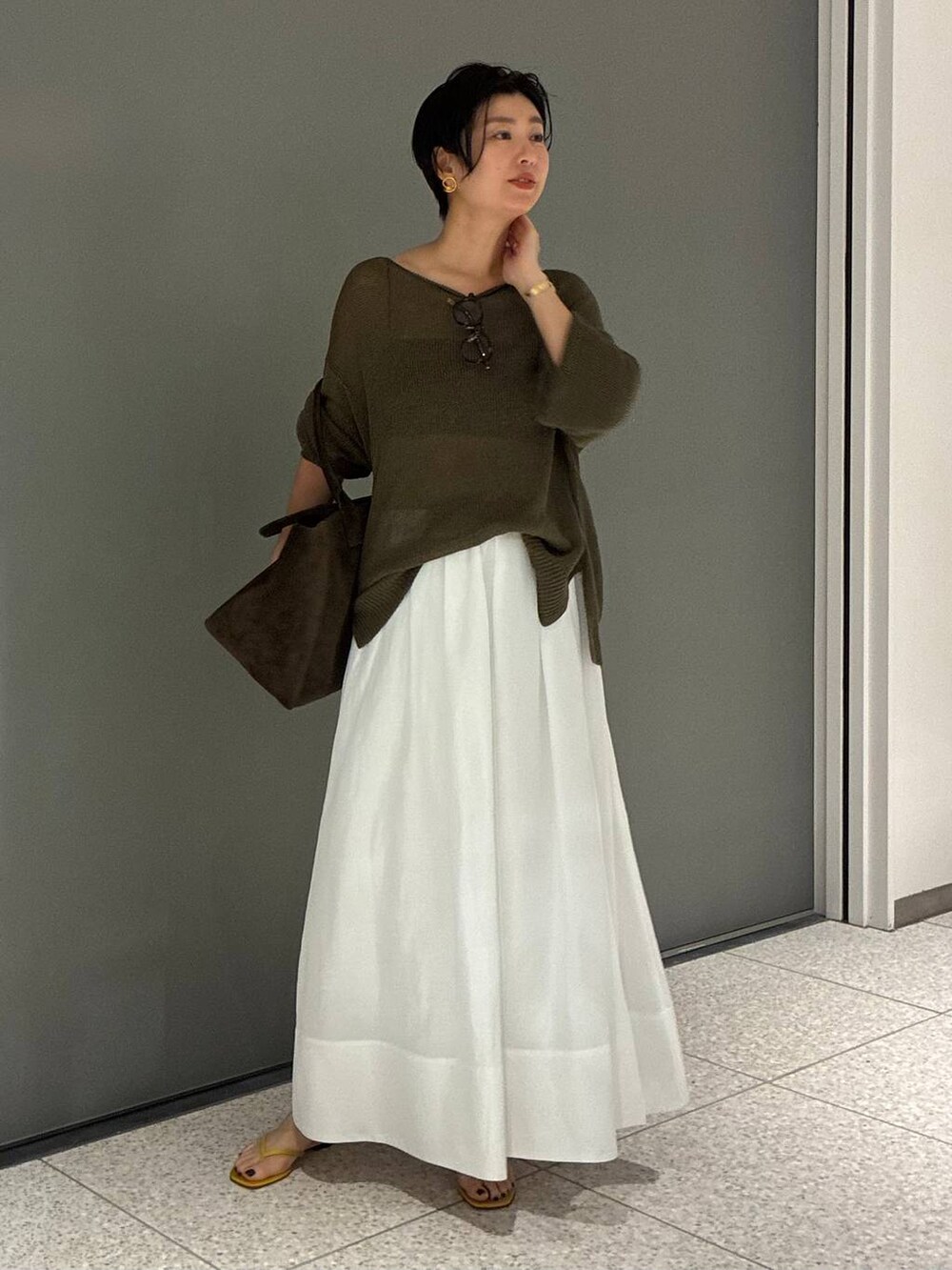 ブラック系のチューブトップ、ブルー系のスカートを着用したレディースの夏コーディネートの6枚目の写真