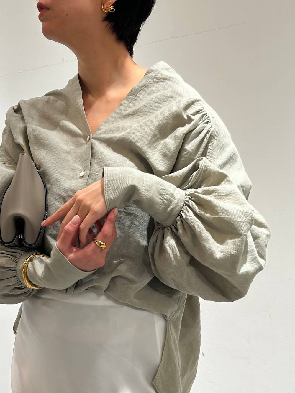 グリーン系のシャツ/ブラウス、ホワイト系のスカートを着用したレディースの春コーディネートの6枚目の写真