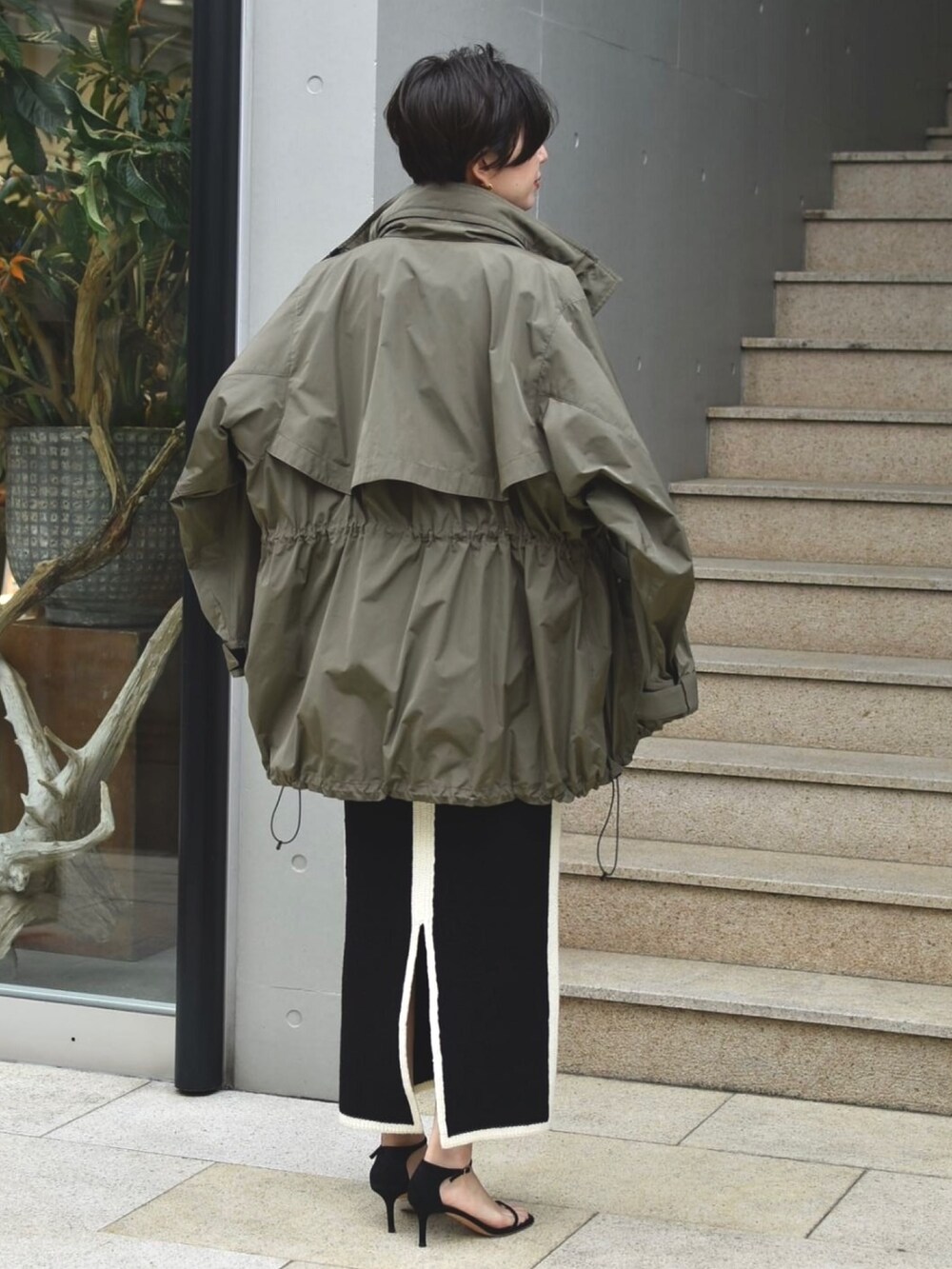 グリーン系のブルゾン、ブラック系のトップス、ブラック系のスカートを着用したレディースの夏コーディネートの3枚目の写真