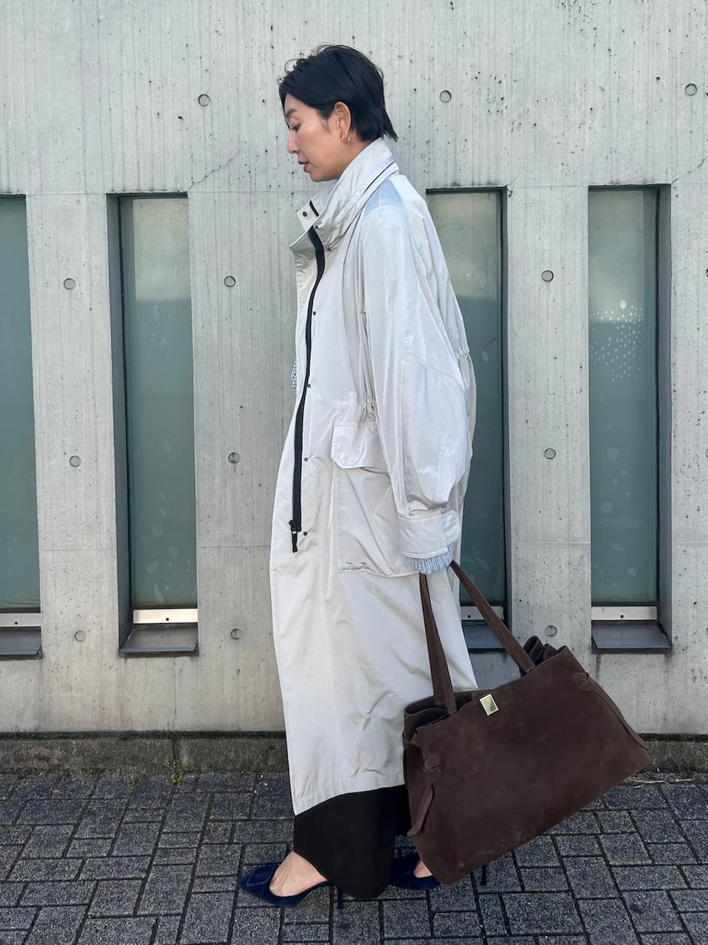 ブルー系のニット/セーター、ホワイト系のその他トップス、グレー系のナイロンジャケットを着用したレディースの冬コーディネートの2枚目の写真