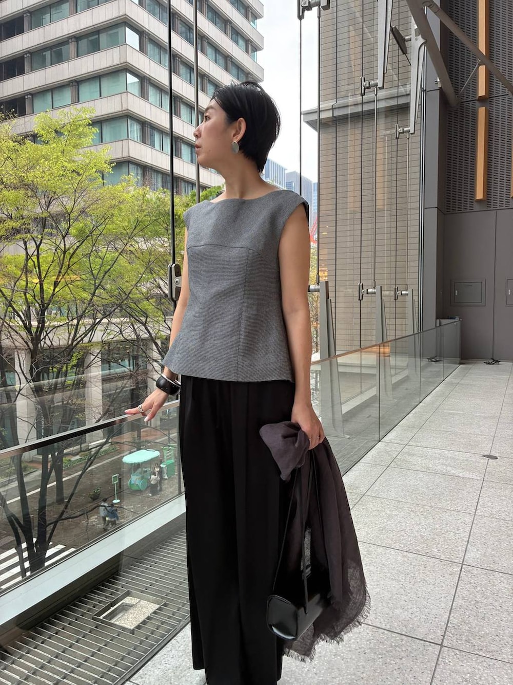 ブラック系のその他パンツ、ホワイト系のその他トップス、ブラウン系のストール/ショールを着用したレディースの春コーディネートの5枚目の写真