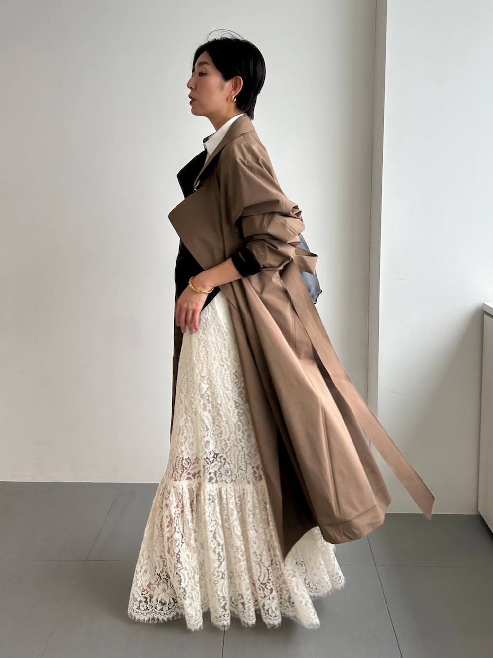 ホワイト系のスカート、ベージュ系のトレンチコートを着用したレディースの冬コーディネートの3枚目の写真