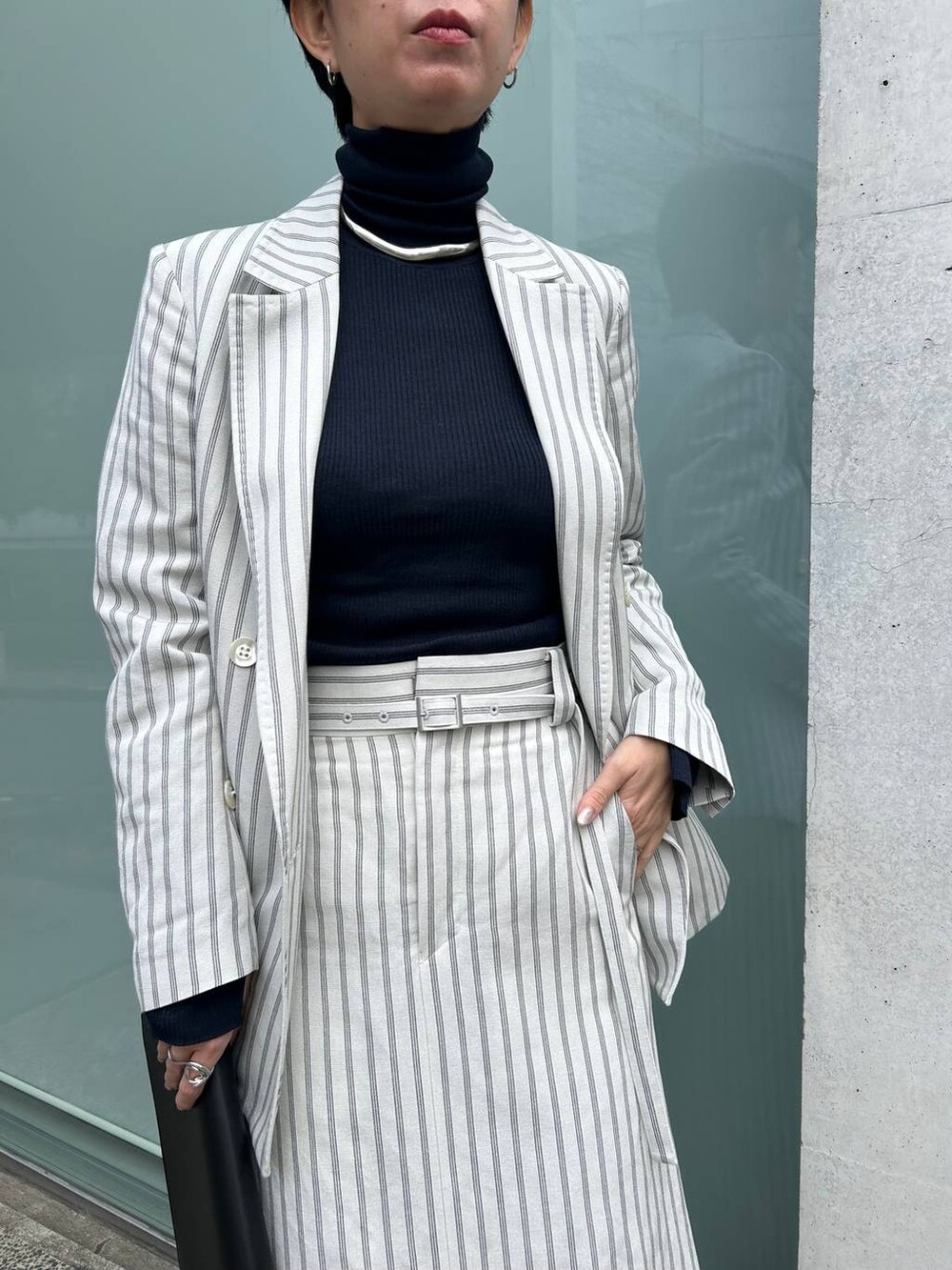 ブルー系のニット/セーター、ホワイト系のテーラードジャケット、ホワイト系のスカートを着用したレディースの冬コーディネートの6枚目の写真