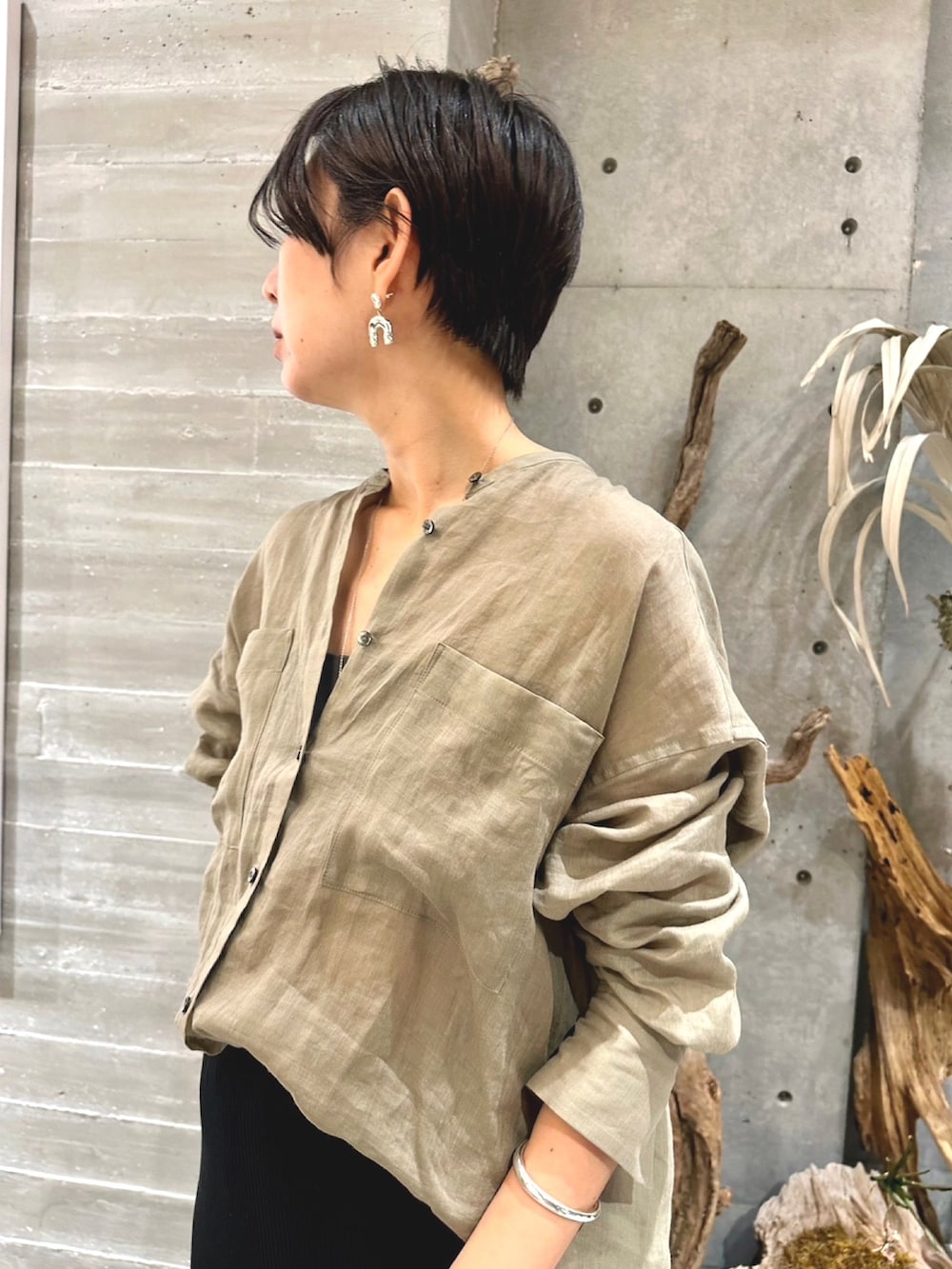 ブラック系のスカート、ブラック系のサンダル、ベージュ系のシャツ/ブラウスを着用したレディースの春コーディネートの4枚目の写真